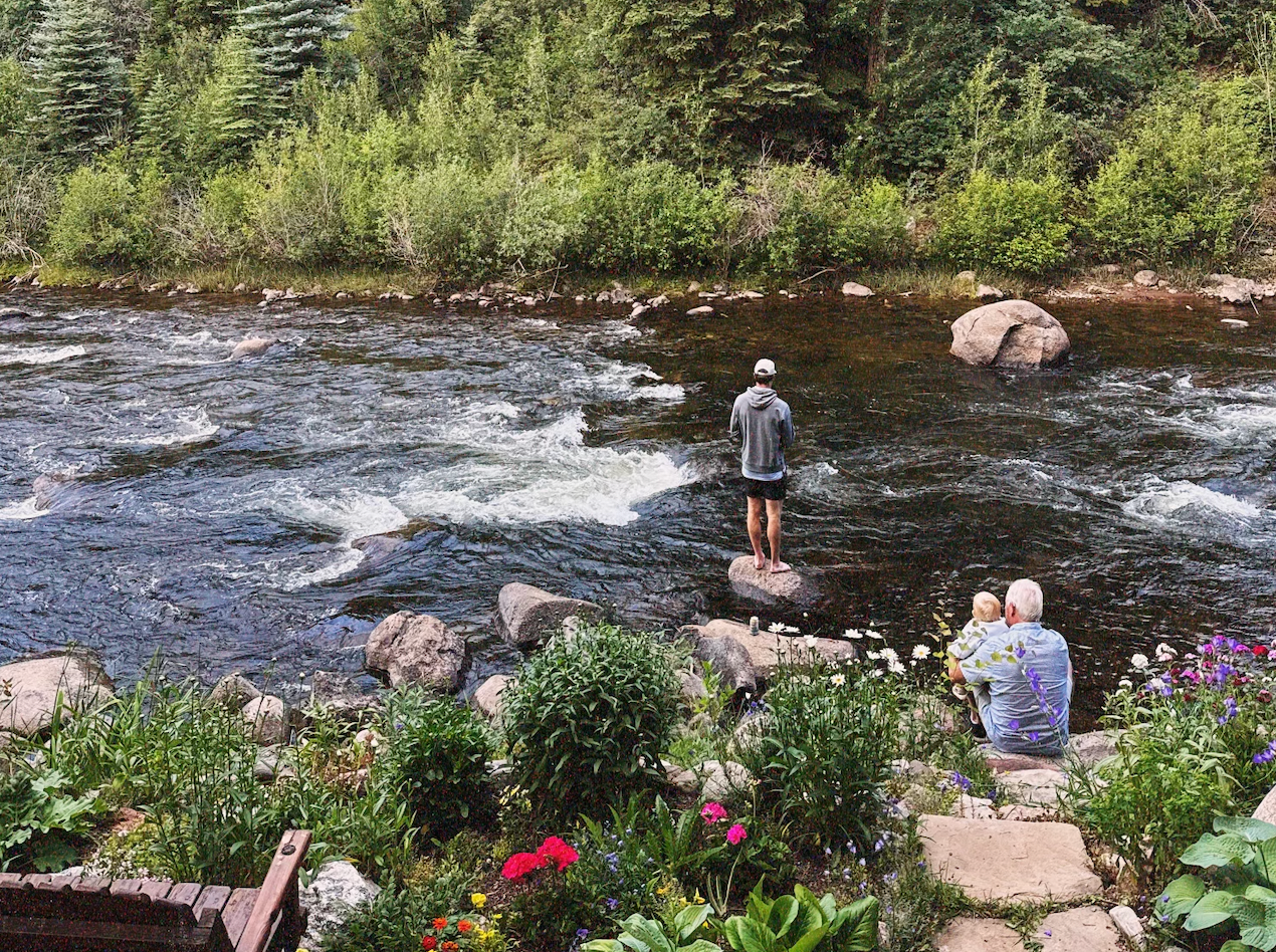 Man fishing in rushing river