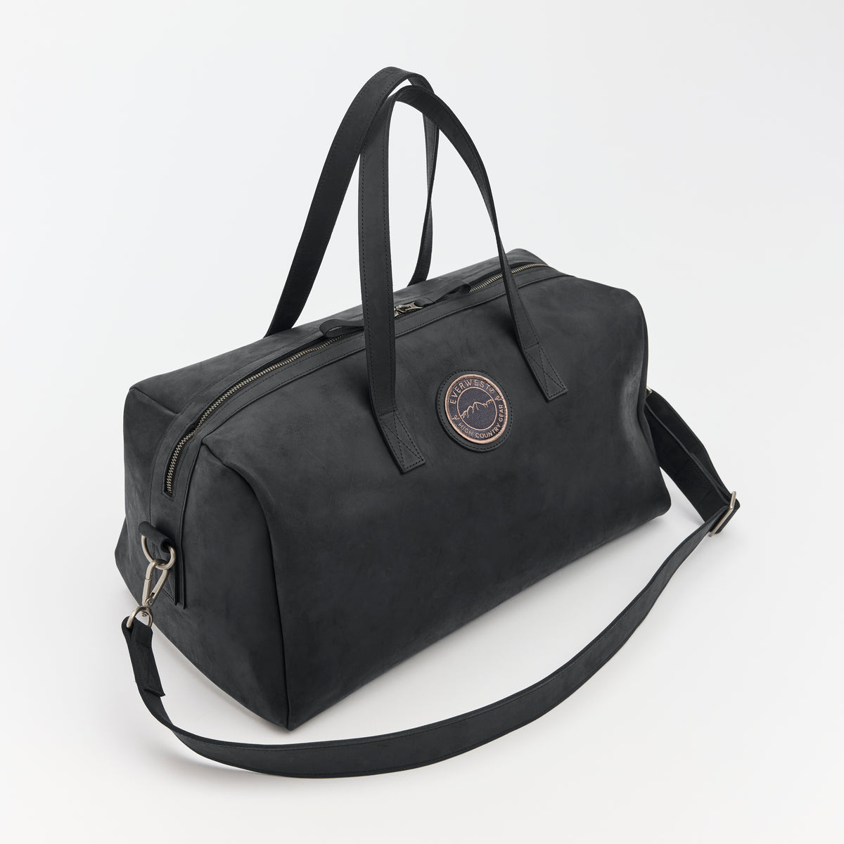 Black leather duffel bag with a strap on a white background