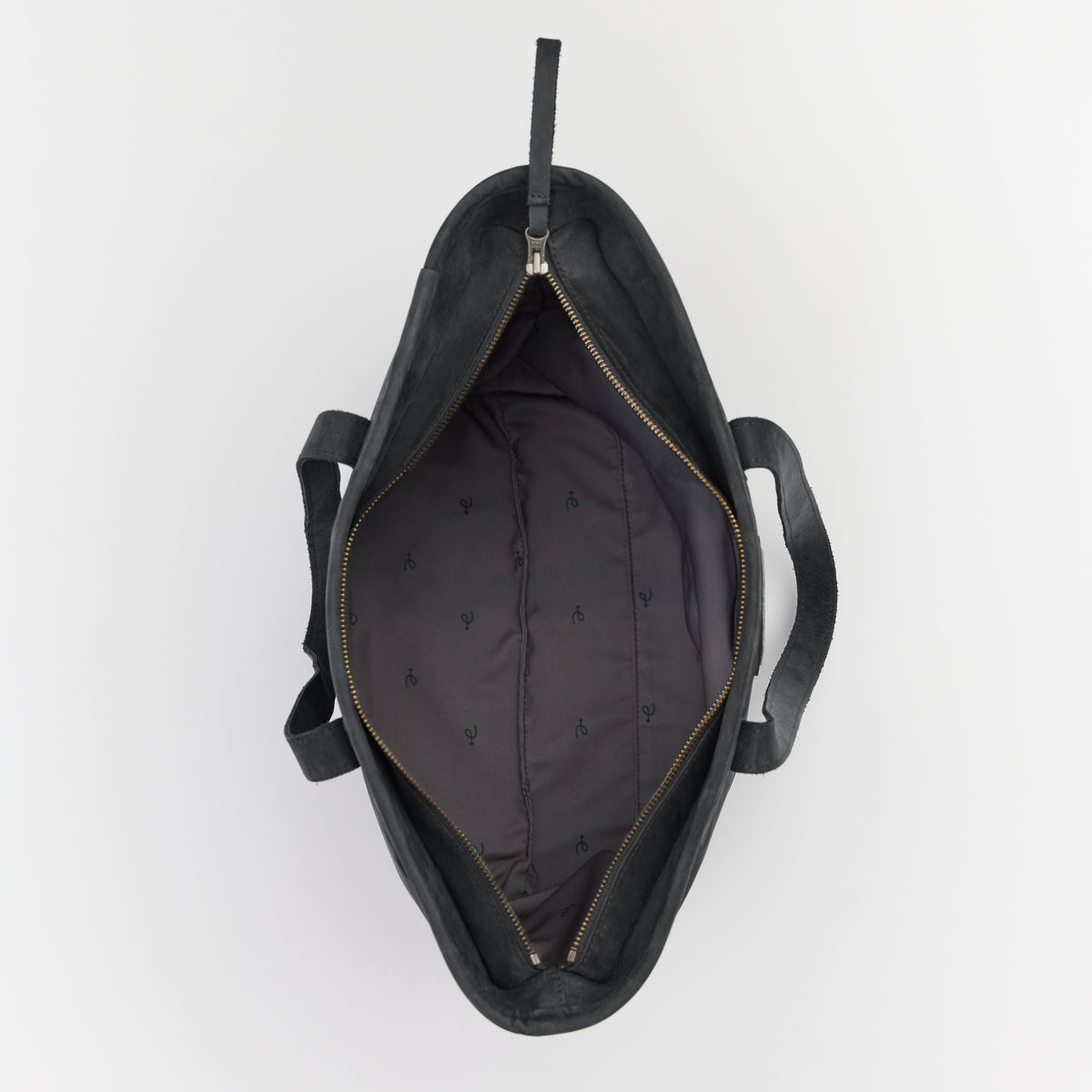 Black leather tote bag with open top zippered compartment on a light gray background