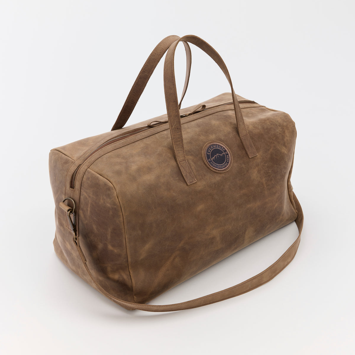A large brown leather duffel bag with the Everwest brand logo on a white background