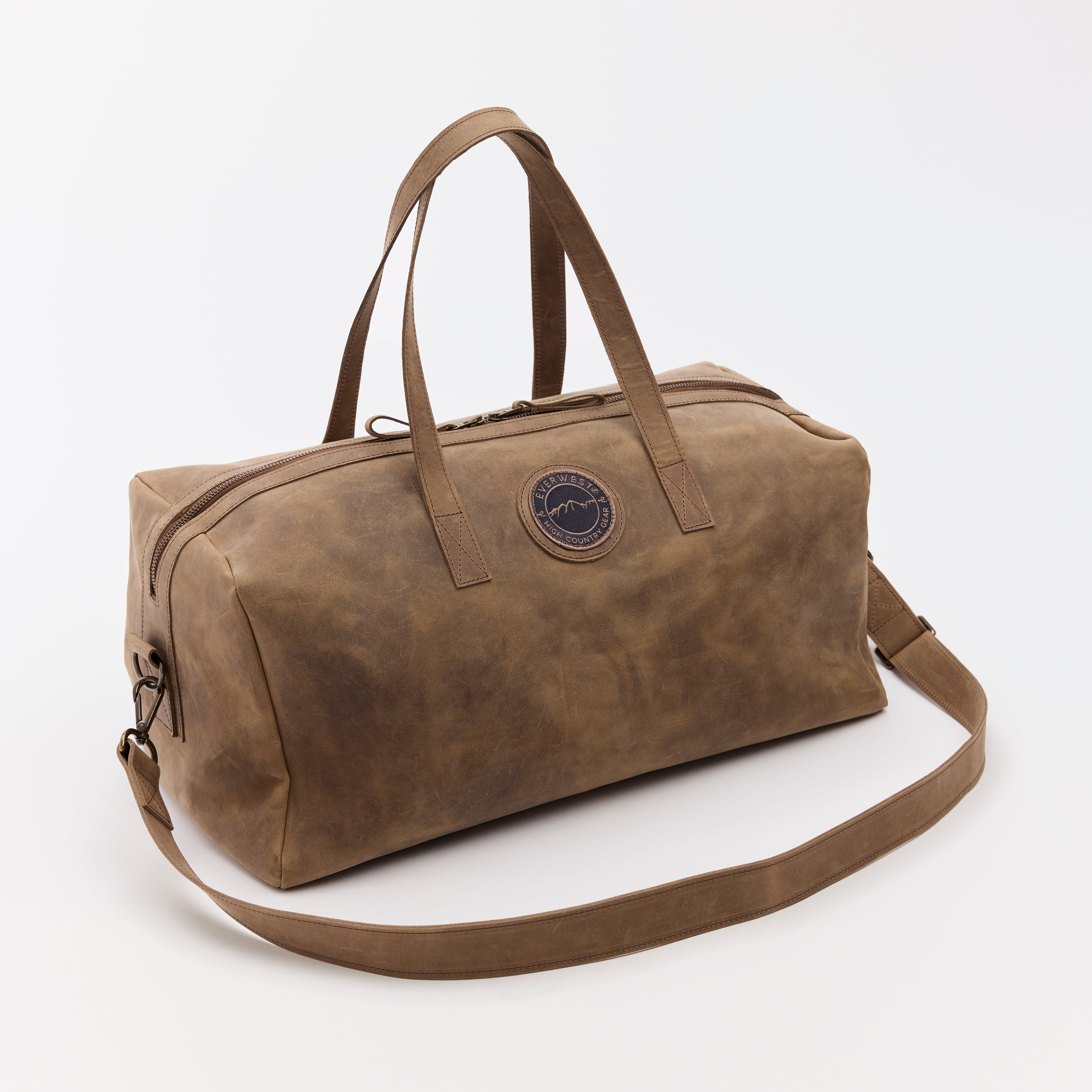 Brown leather duffel bag with a strap on a white background