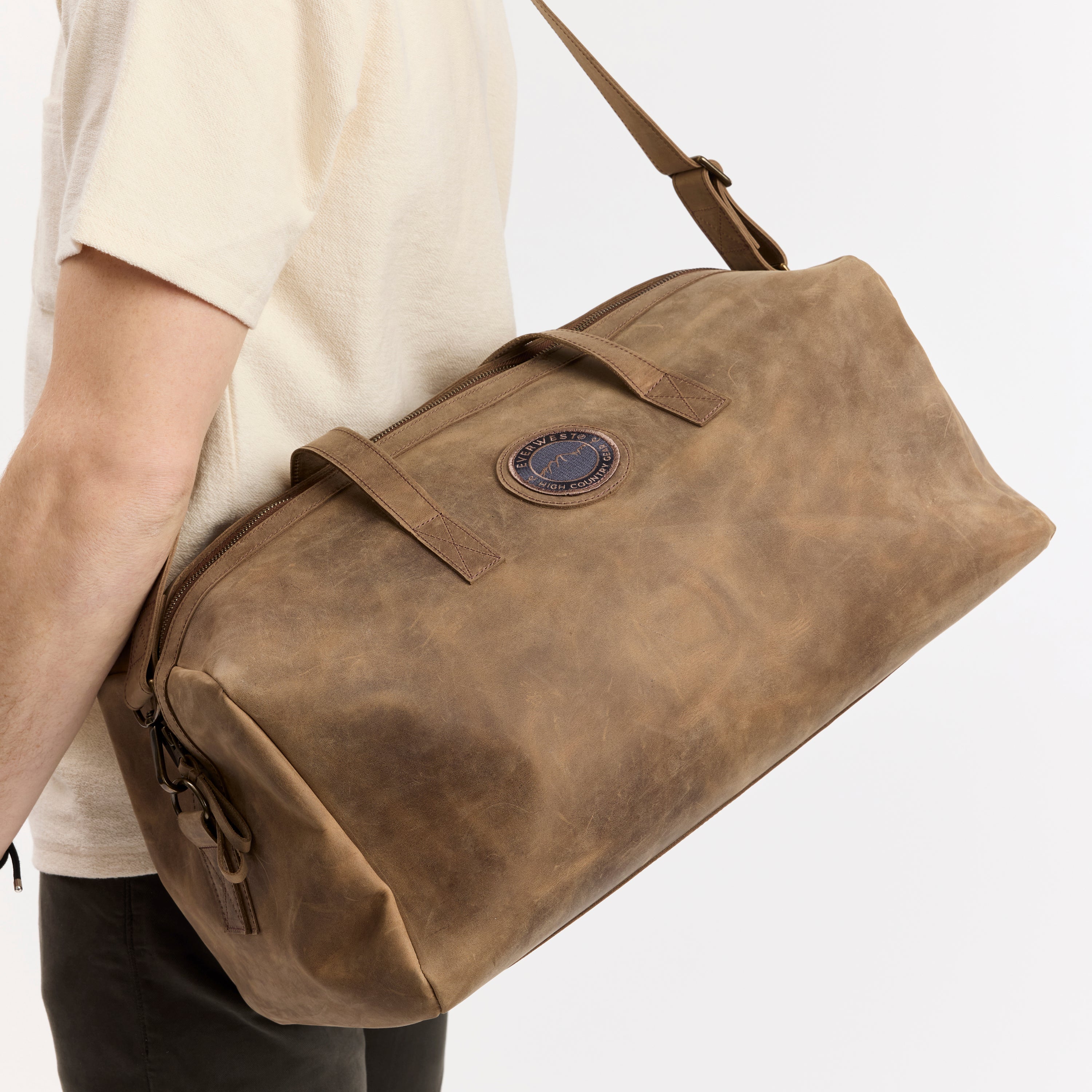 Brown leather duffel bag with a visible Everwest brand logo on a white background