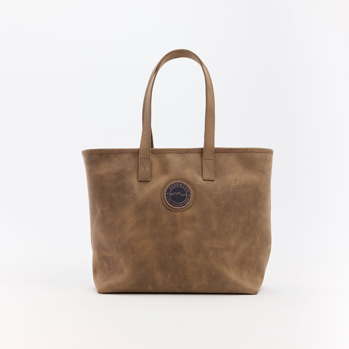 Brown leather tote bag with the Everwest brand logo patch on a white background