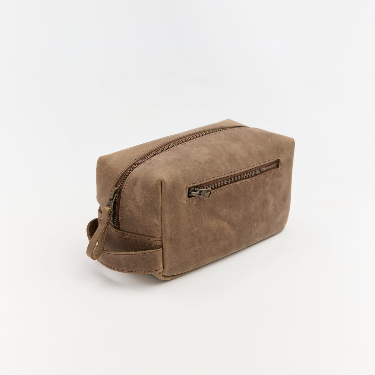 Brown leather toiletry bag with zipper on a white background
