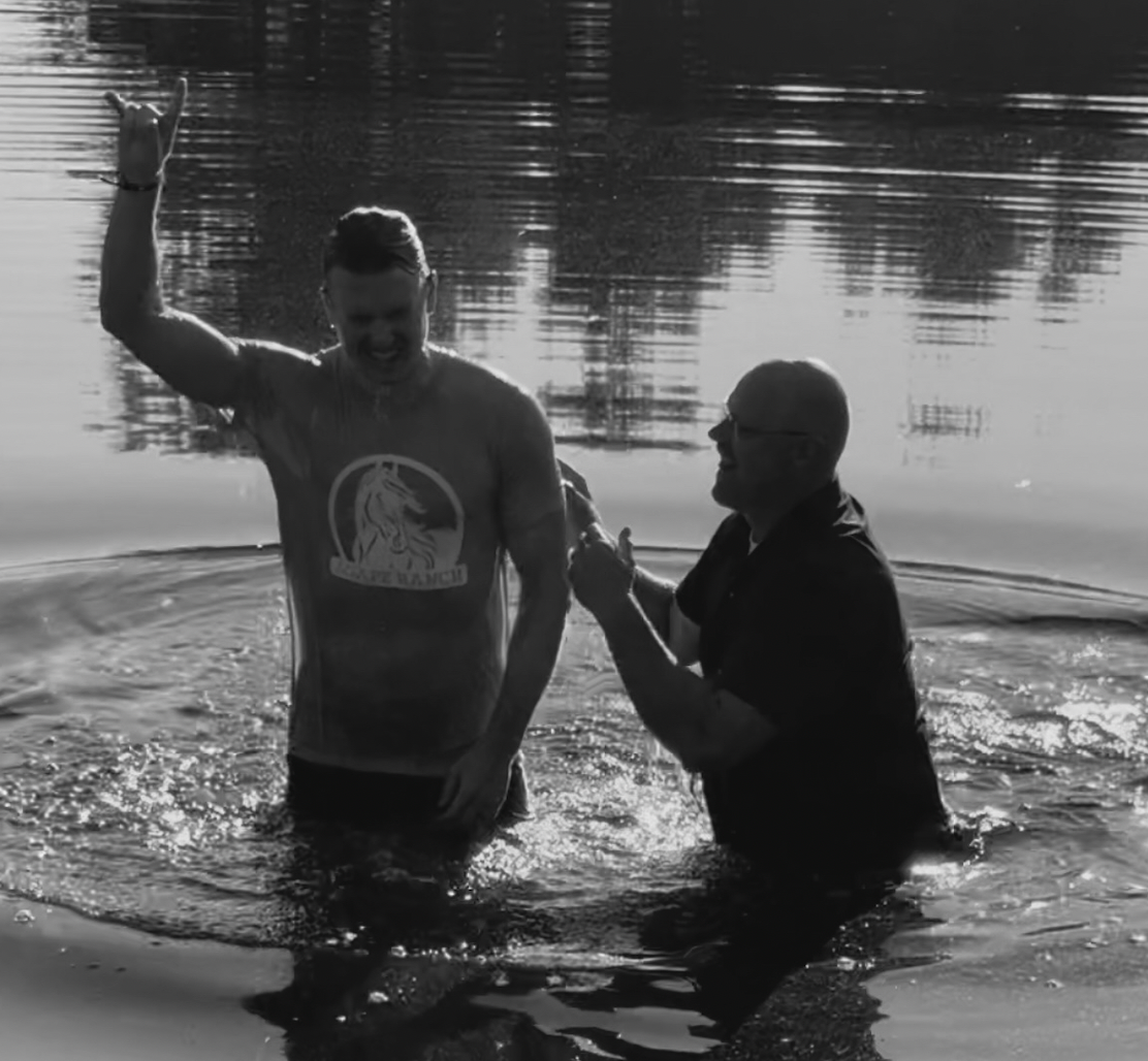 Man being baptized in a pond