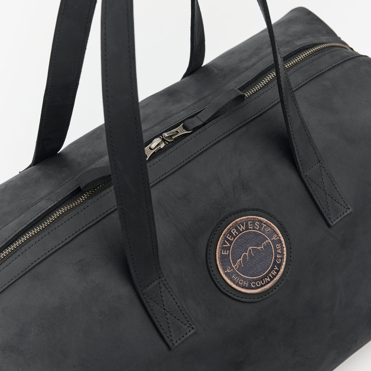 Black leather duffel bag with a visible brand logo on a white background