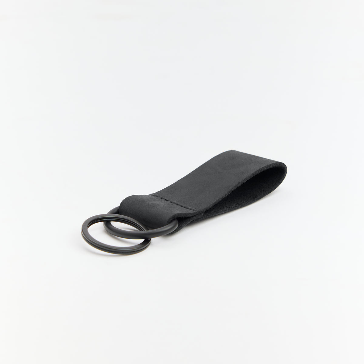 Black leather keychain with a ring on a white background