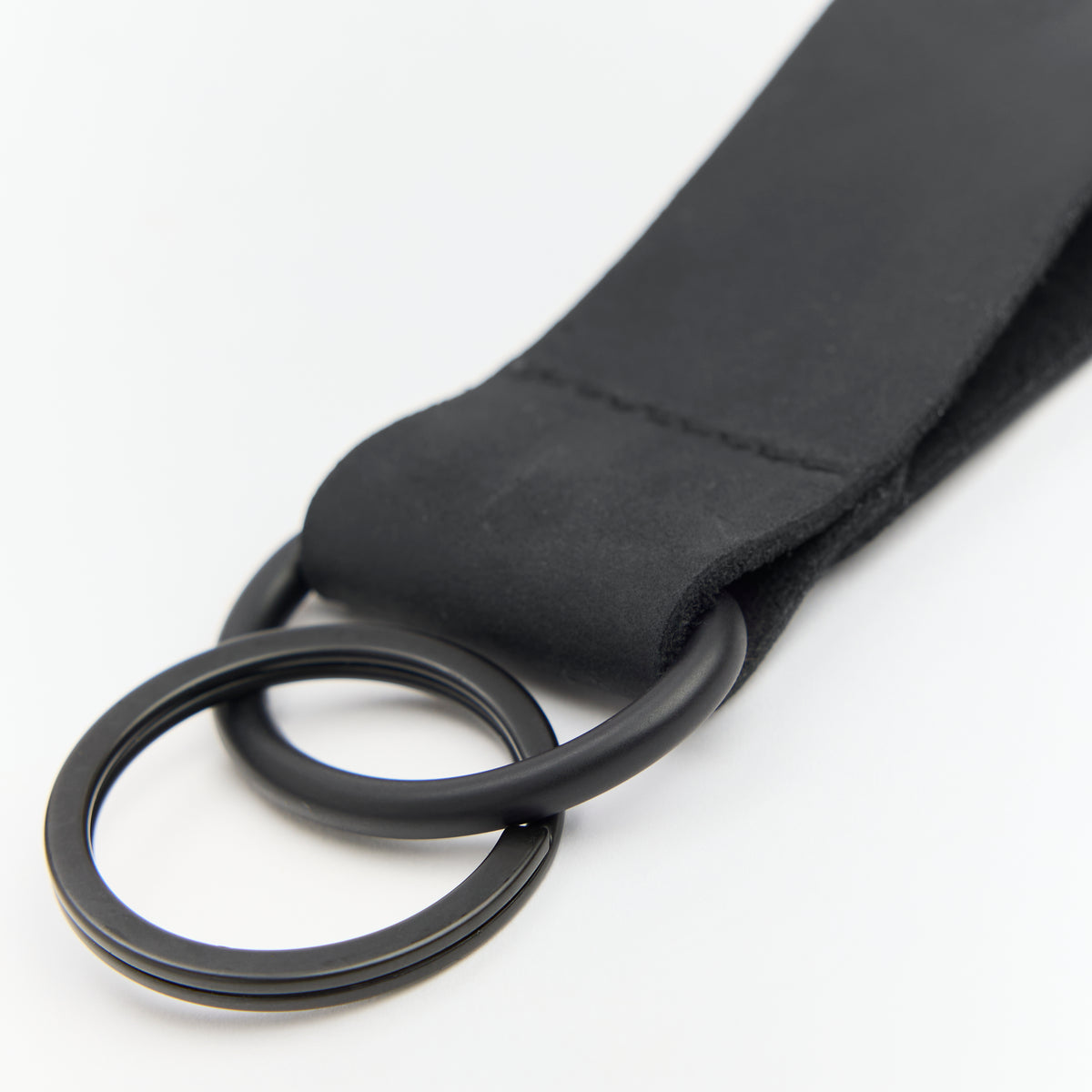 Black leather keychain with a metal ring on a white background