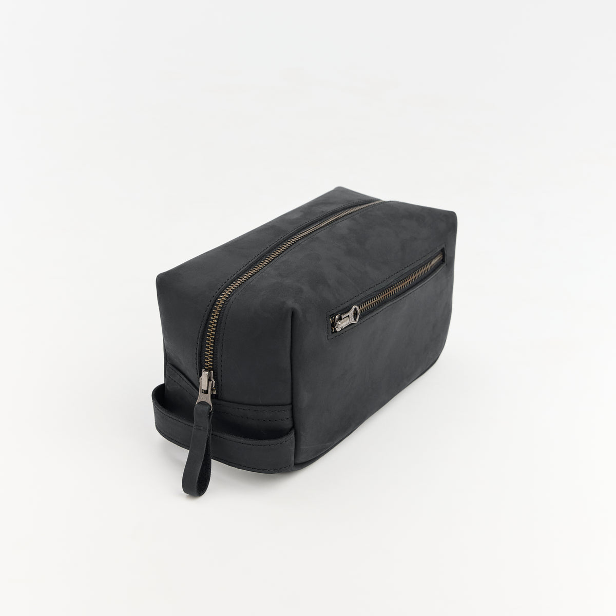 Black leather toiletry bag with zipper on a white background