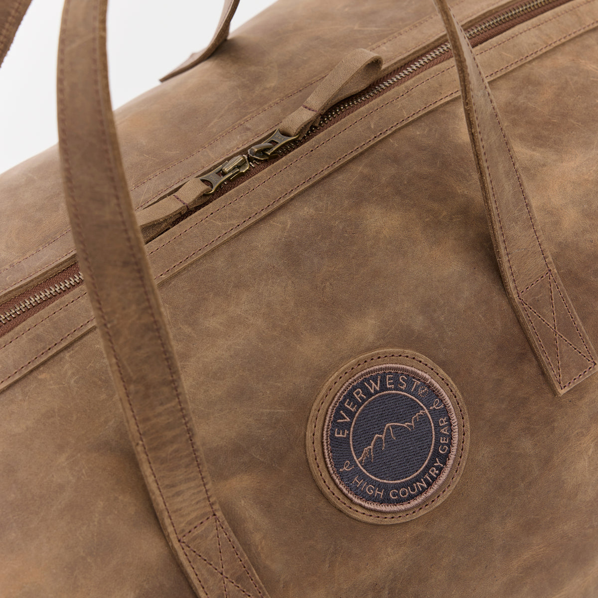 Large brown leather bag with Everwest High Country Gear logo patch stitched into the side.