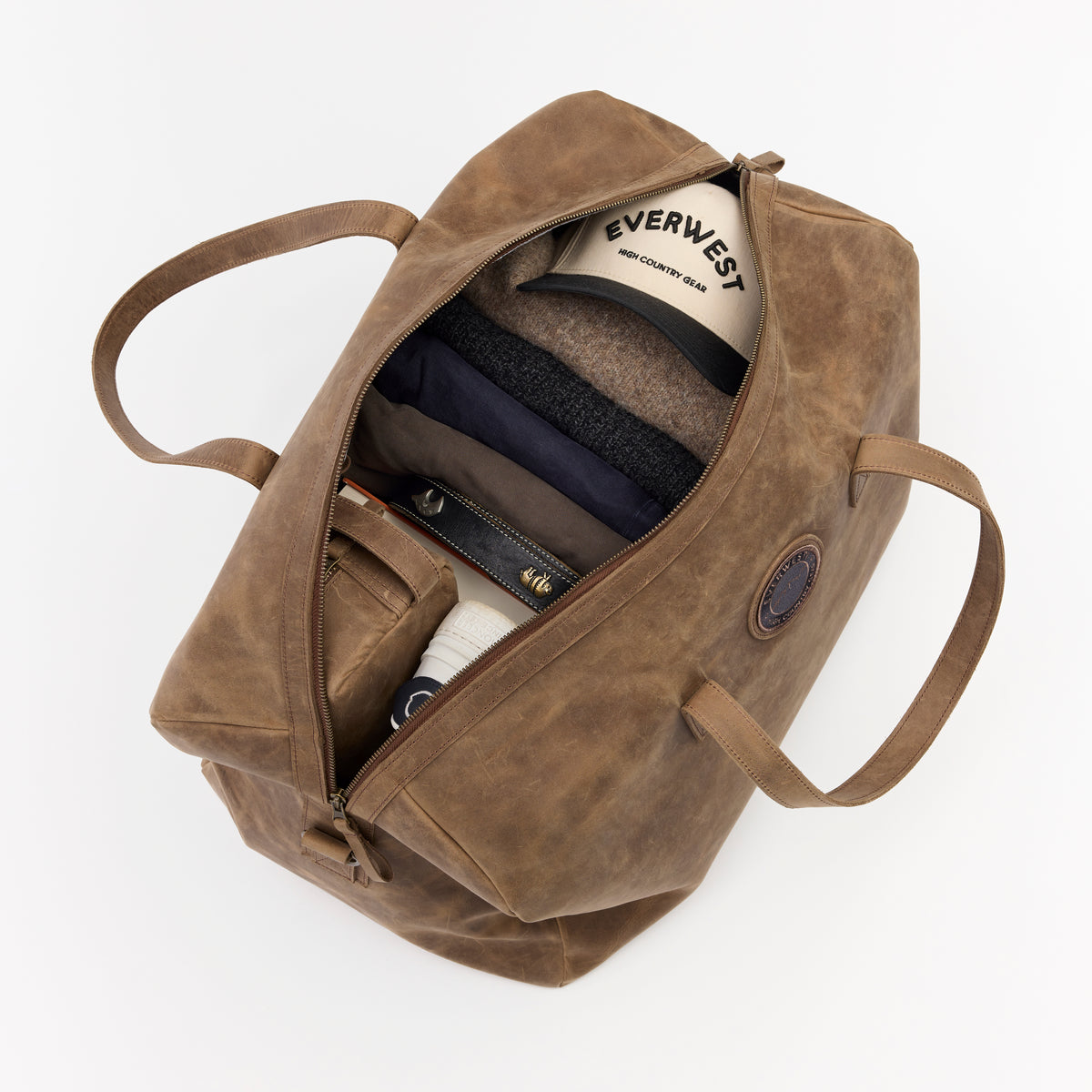Large brown leather duffel bag with visible brand name on a white background