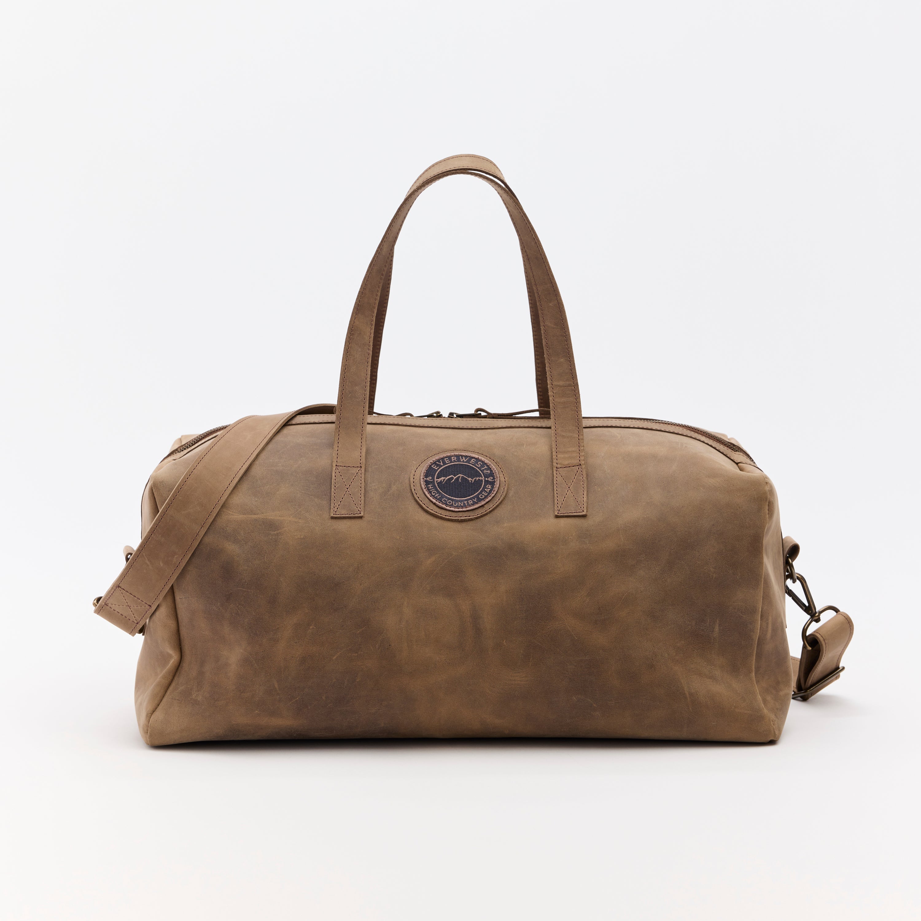 Brown leather duffel bag with a visible brand logo on a white background