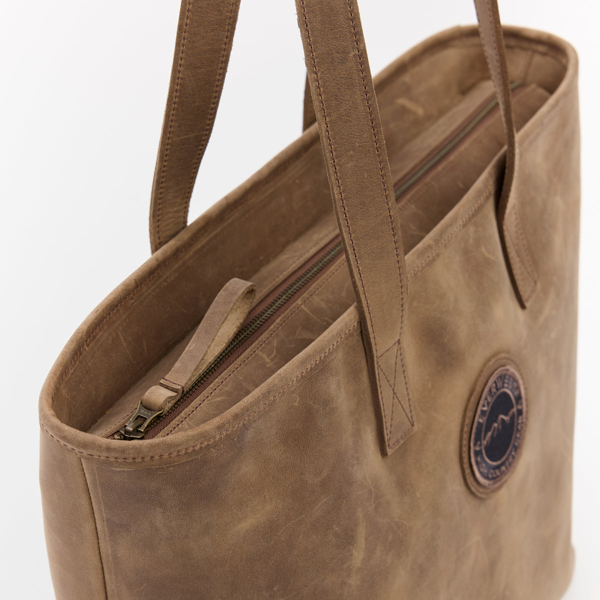 Brown leather tote bag with a visible brand logo on a white background
