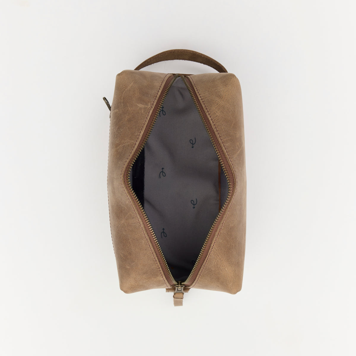 Brown leather dopp kit with zipper on a white background