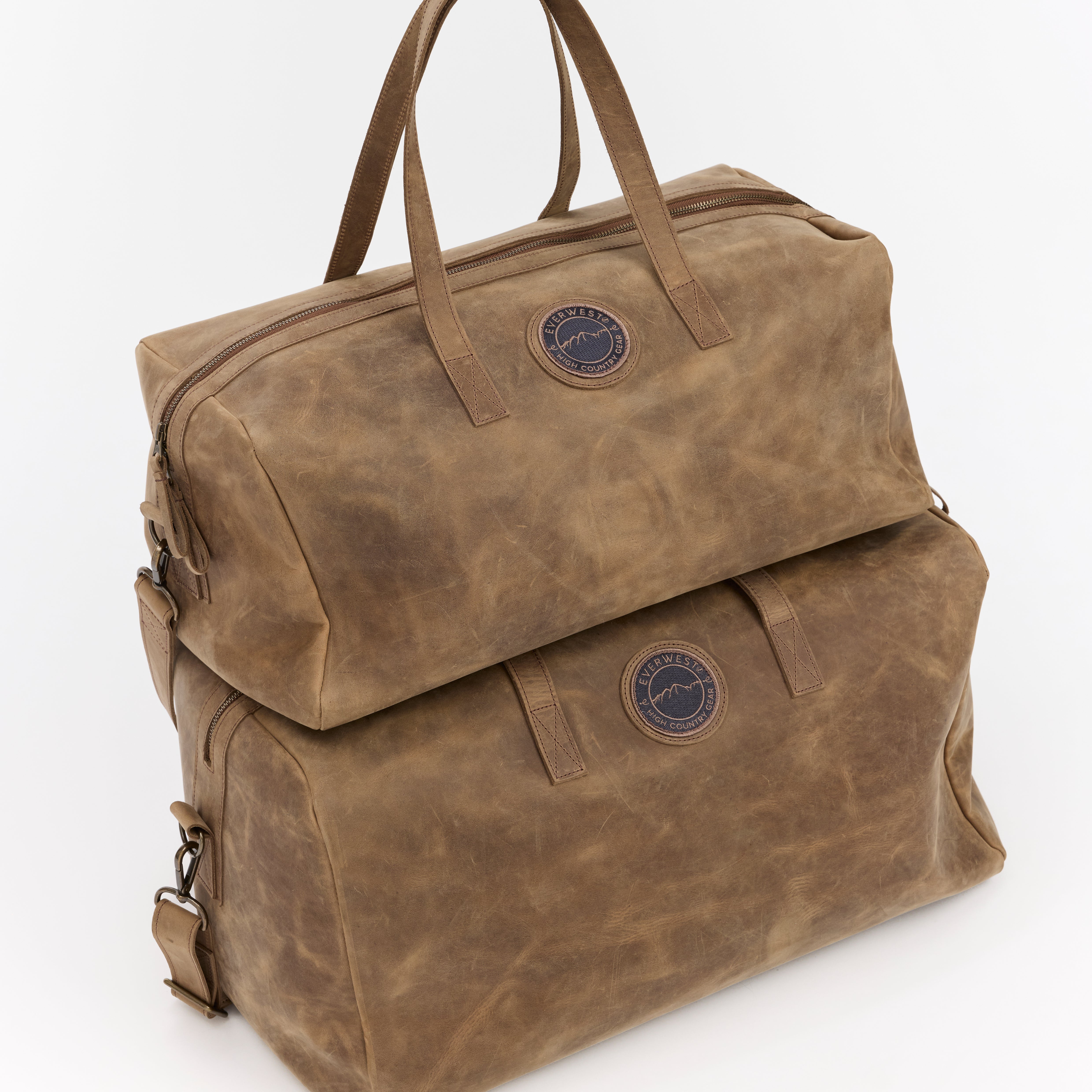 Two different size brown leather weekender bags with the Everwest brand logo on a white background